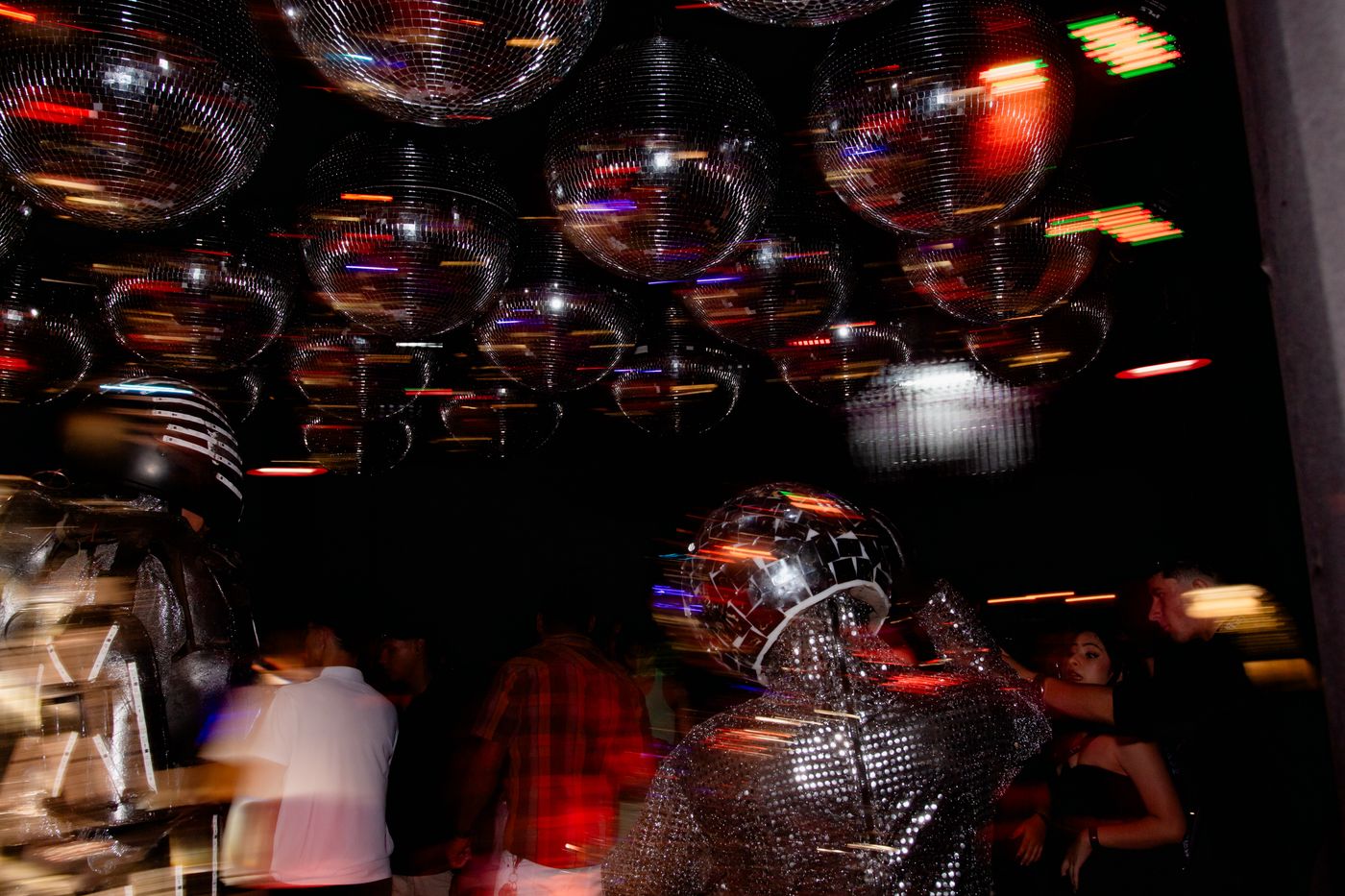 Dansend publiek onder een plafond vol discoballen