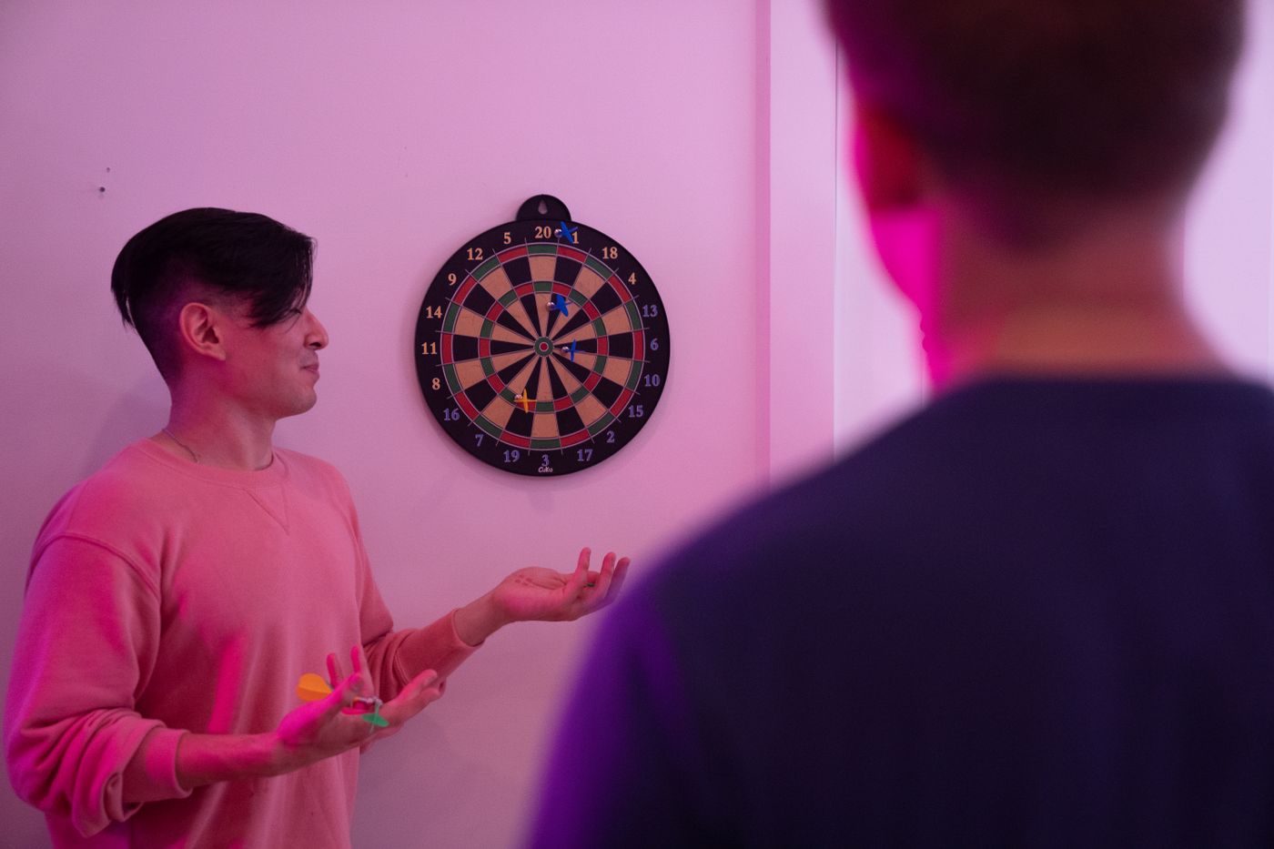 Twee spelers gooien pijltjes op het dartbord