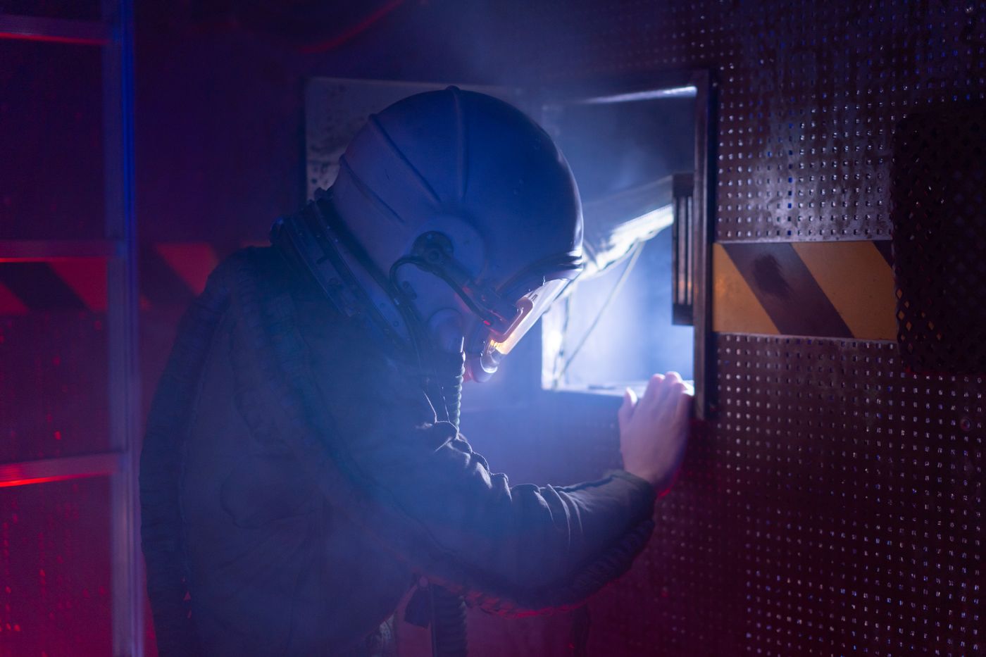 Speler zoekt aanwijzingen bij een verlicht paneel in de escaperoom