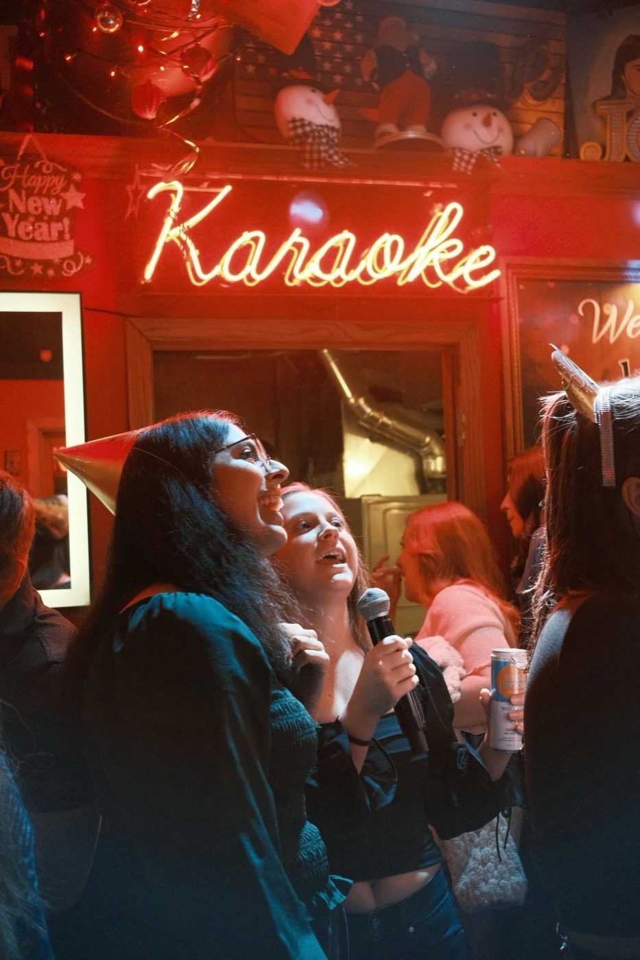 Neonbord met de tekst Karaoke boven zingende gasten