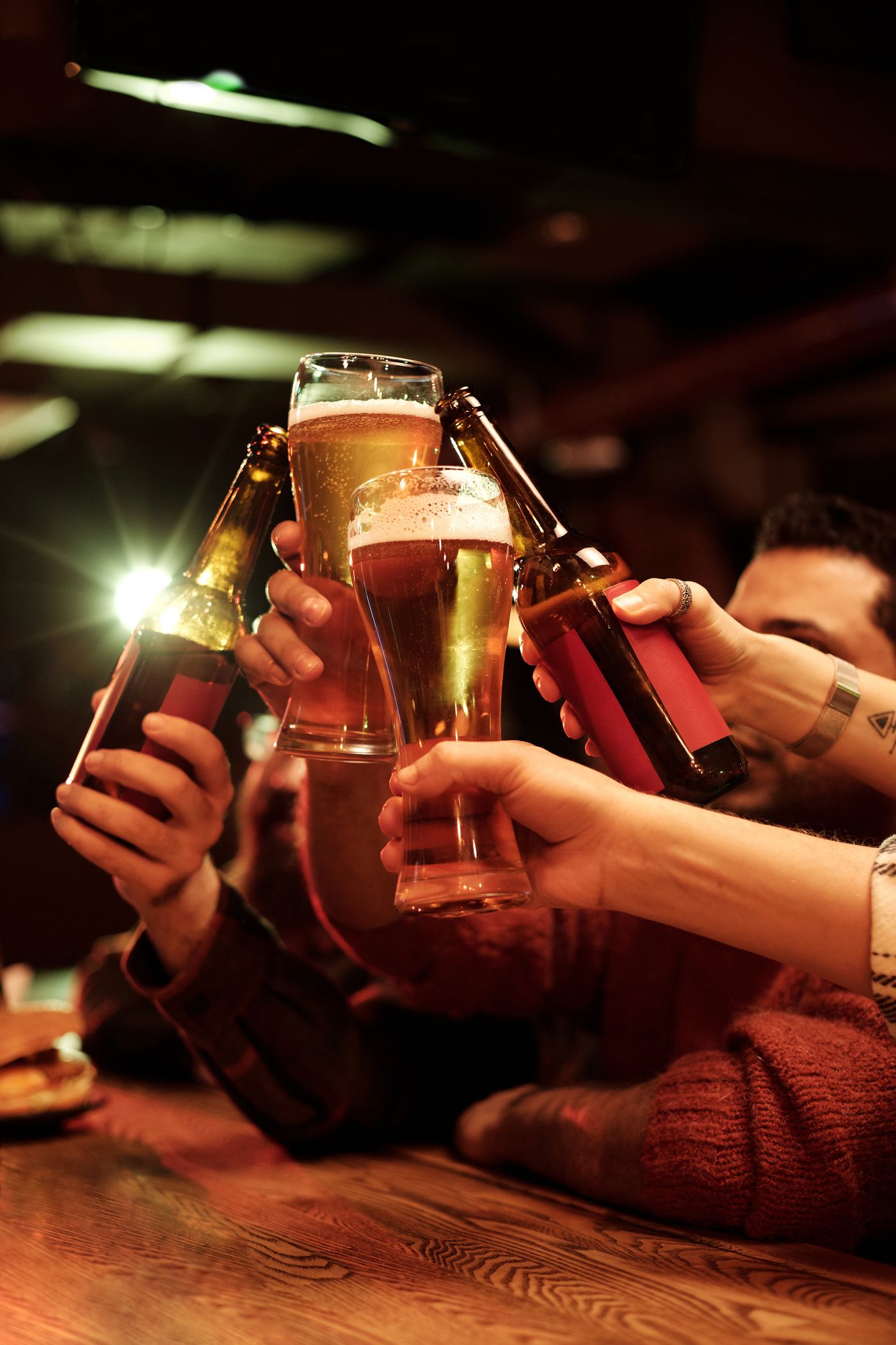 Vrienden proosten met bier in de bar